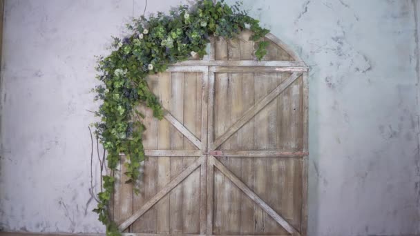 Beautiful photo zone: wooden gate and arch of flowers — Stock Video