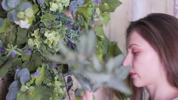 Flickan kommer till blommorna, dekorerar dem med en gren av eukalyptus, då lämnar bildrutan — Stockvideo