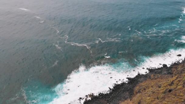 Aéreo - As ondas atingiram a praia preta com espuma — Vídeo de Stock