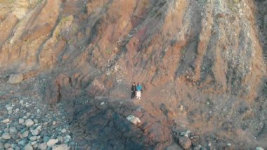 Havadan ateş. Kamera, büyük kayaların dibinde duran kadın ve erkekten uzaklaşıyor. Benijo, Tenerife, İspanya