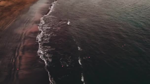 Luftaufnahme eines schwarzen Strandes mit vulkanischem Sand, eines mehrfarbigen Strandes - schwarz, rot, orange. teneriffa, spanien. — Stockvideo