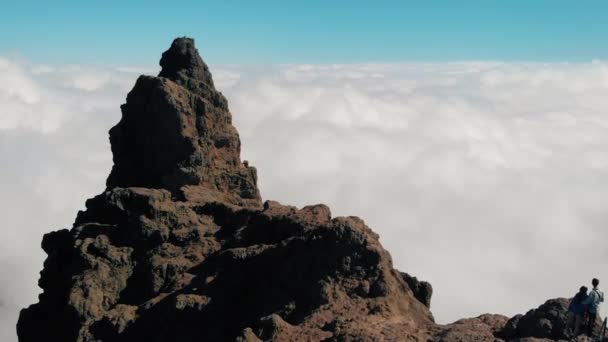 Aerial view. A young couple stands on the edge of the cliffs above the clouds. The camera moves to a large cliff above the clouds. Gran Canaria, Canary Islands, Spain — Stock Video