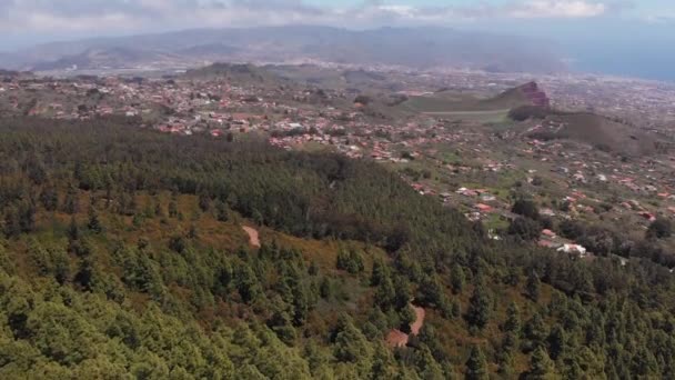 Vista para os olhos dos pássaros. A câmera vai para baixo - em uma floresta de coníferas e uma bela estrada nas montanhas, ao longo do qual os carros viajam através das árvores no alto do cume — Vídeo de Stock