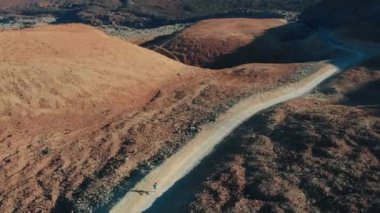 Havadan görünüm. Genç bir hipster kız yanardağ bir yaya yolu üzerinde dağlarda çalışır.