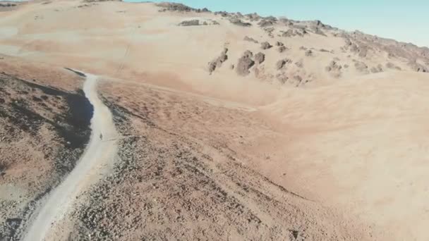 Luftaufnahme - ein junger Mann wandert zu einem Vulkan durch die Wüste, Teide-Nationalpark, Teneriffa — Stockvideo