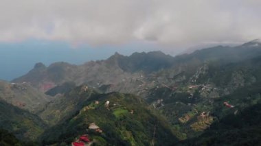 Dağlarda yüksek güçlü rüzgar, vadi ve dağ aralığında küçük köylerin havadan görünümü