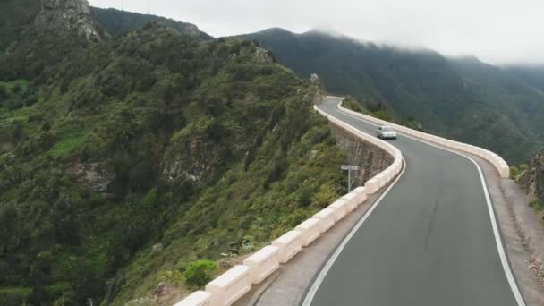 Αεροφωτογραφία. Το αυτοκίνητο πηγαίνει στο δρόμο που είναι στρωμένος ψηλά κατά μήκος του βουνού σερπεντίνη. Τενερίφη, Ισπανία — Αρχείο Βίντεο