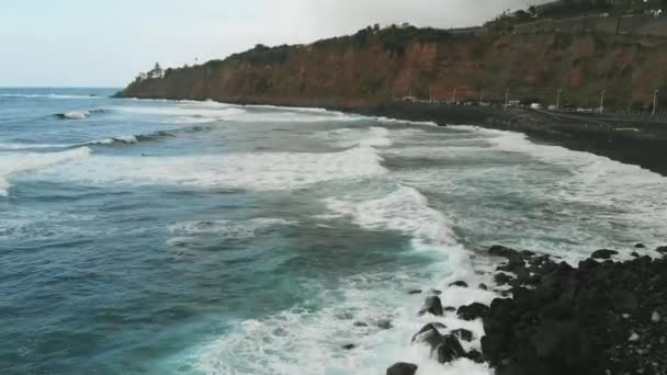 Havadan görünüm. Turkuaz rengi güzel dalgalar siyah kum ile kıyıya düşmek. Tenerife, Playa del Socorro — Stok video