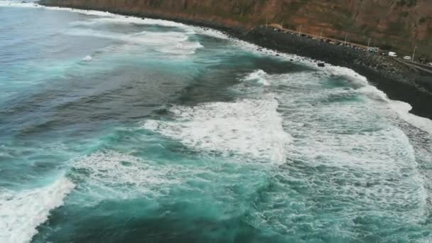 Playa del Socorro – malá útulná pláž s černým vulkanickým pískem a cinematické výhledy na Atlantský oceán. Obrovské vlny tyrkysové barvy padají na pobřeží ostrova Tenerife, Španělsko — Stock video