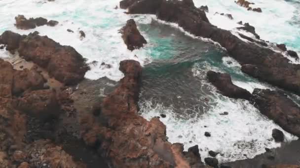 Donmuş lav kayalıklarından yaratılan güzel koy, volkanik kumlu bir plaj ve Atlantik Okyanusu. Doğal bir havuzun havadan görünümü — Stok video