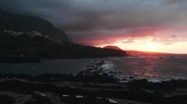 Havadan görünüm - Garachico, küçük bir koy ve Atlantik Okyanusu kıyısında pitoresk İspanyol kenti kasabası yakınlarında gün batımı. Sinematik uçuş.