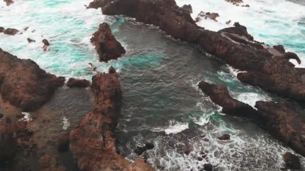 Luftaufnahme aus der Ferne - eine Person steht am Rand eines Felsens vulkanischen Ursprungs, der Meeresküste. teneriffa, spanien — Stockvideo