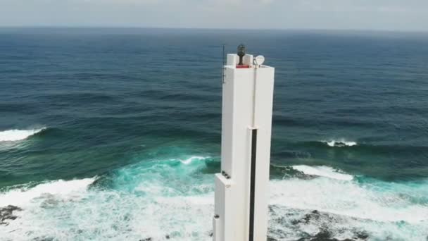 Vakkert, hvitt fyrtårn ved atlanterhavskysten, solskinnsdag, utsikt fra luften. Punta del Hidalgo fyr – stockvideo