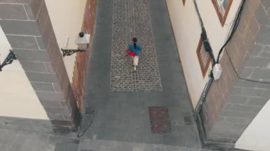 Yukarıdan aşağıya görünüm. Genç bir kadın Gran Canaria adasının başkenti eski kentin dar bir cadde boyunca yürür, bir kuş bakışı görünümü.