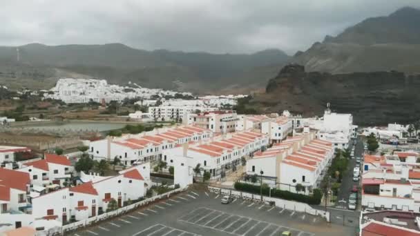 Sopra. Il villaggio ai piedi delle montagne nebbiose case bianche con un tetto arancione, architettura spagnola, case vacanze. Vista a volo d'uccello . — Video Stock