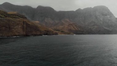 Güzel sinematik aero çekim - büyük sisli dağlar ve karanlık ve derin Atlantik Okyanusu, insanlar olmadan. İnsansız hava aracından manzara, panoramik manzara. Parque Doğal Tamadaba, Agaete, Gran Canaria.