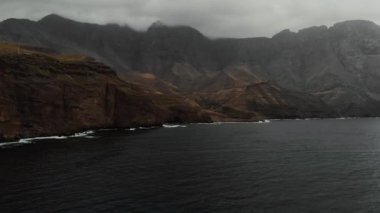 Bulutlu bir günde Atlantik Okyanusu kıyılarındaki büyük dağların panoramik manzarası. Kuşların bakışı. Agaete, Gran Canaria
