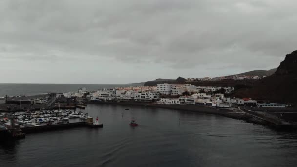 Vue aérienne - petit bateau de pêche naviguant sur une petite baie près de la ville d'Agaete, Espagne. Oiseaux cinématiques vue — Video