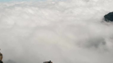 Dağın altında çok sayıda bulutlar, çok yüksek bir irtifadan görünüm, bir kaya üzerinde uçan bir drone, Pico de las Nieves, Gran Canaria