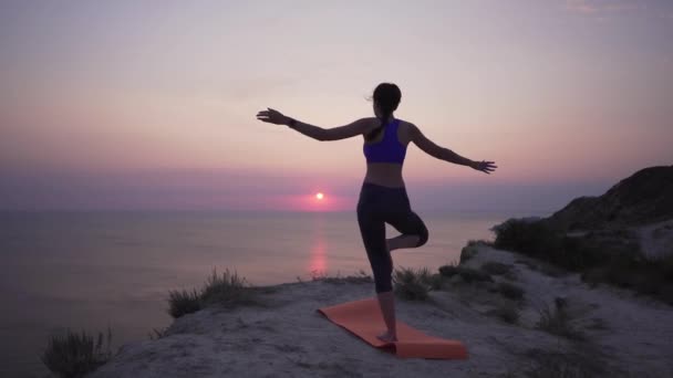 Buitensporten. Het meisje krijgt geen yoga pose, ze is boos en probeert de positie te leren. — Stockvideo