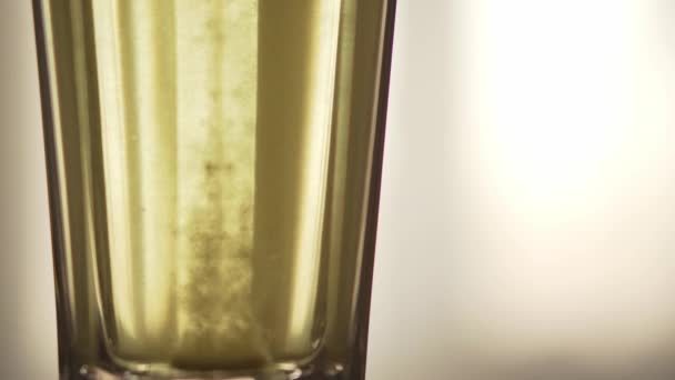 Een tablet oplost in een glas water close-up. Een snelle remedie voor verkoudheid tijdens de herfst griepepidemie. Het concept van geneeskunde, preventie en behandeling — Stockvideo