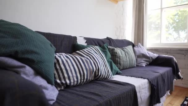 Hygge o concepto Lagom - un acogedor sofá con una gran cantidad de almohadas y mantas con colchas — Vídeo de stock