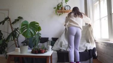 Kafkas genç kadın yumuşak bir kanepe üzerinde oturur ve bir battaniye ile kapak alır - Hygge veya Lagom kavramı