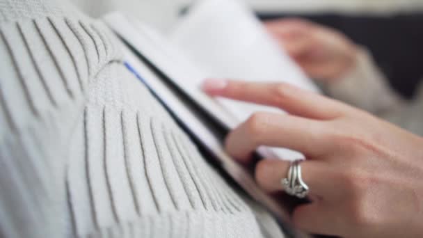 Primer plano - mujer hojeando las páginas de un libro, sosteniéndolo en un acogedor cuadros — Vídeos de Stock