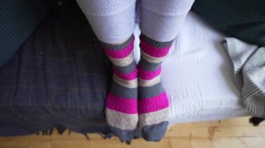 Kahverengi-pembe sıcak örme çorap kadın bacaklar yakın çekim bir battaniye ile rahat bir kanepe üzerinde. Lagom'un yaşam felsefesi, minimalizm ve basit şeylerden zevk alma becerisi