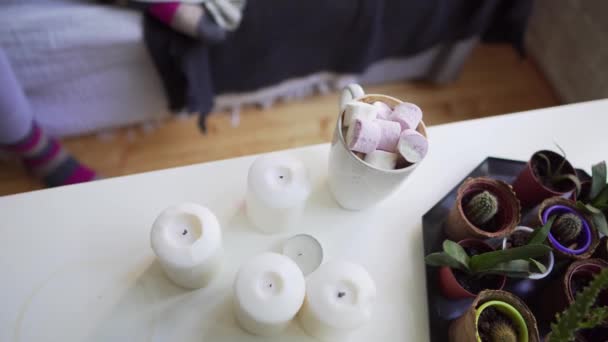 Girl takes a hot drink with marshmallows from a white table, flat lay — Stock Video