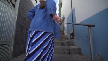 Şık kadın eski İspanyol şehrinde çok dar bir sokakta merdivenlerden yukarı çalışır. Bir turist El Pris, Tenerife, İspanya şehir etrafında yürüyor