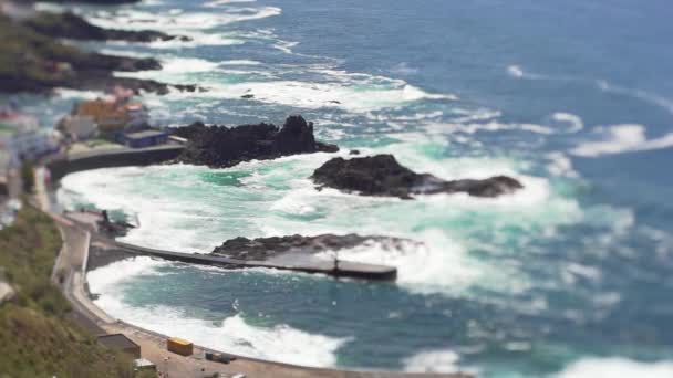 Blick aus der Höhe des Ozeans und einer kleinen spanischen Fischerstadt. Neigungsverschiebung Ozeanlandschaft — Stockvideo