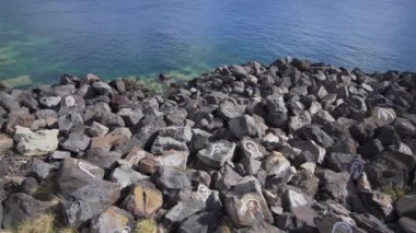Santa Cruz de Tenerife, İspanya - 17 Nisan 2019 - Ünlü çizimleri ile okyanusta Taşlar. Ünlü insanlar Tenerife kıyısında boyalı, bilinmeyen cazibe