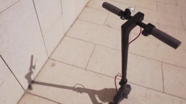 Elektrikli scooter'ın detayı. Akıllı scooter güneşli bir günde dışarıda gölge düşürüyor