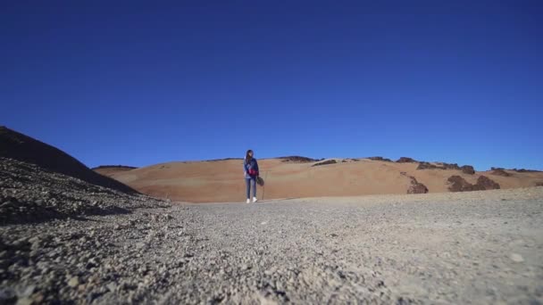 Hipster kvinna går förbi kameran genom vulkanen, öken natur, torra klimat. Statisk bild, vidvinkel. Inspirerande turism — Stockvideo