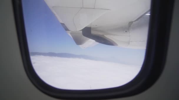 Η θέα από το παράθυρο-μια πτέρυγα αεροπλάνων και μια μηχανή Turbo σε πτήση πάνω από τα σύννεφα. Αεροπορικών μεταφορών — Αρχείο Βίντεο