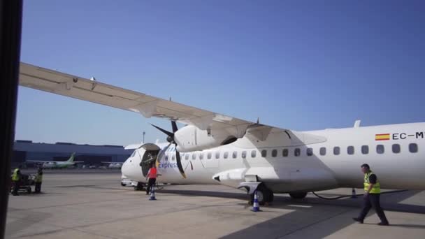 Las Palmas de Gran Canaria, Hiszpania-Kwiecień, 22, 2019-samolot po lądowaniu, personel lotniska pracuje z płaszczyzną śmigła. Wkładka przechodzi akcję przed lotem — Wideo stockowe