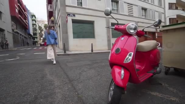 Las Palmas de Gran Canaria, ESPAÑA - 23 de abril de 2019 - Un hermoso ciclomotor rojo, desde el que una mujer hipster con estilo va a la vieja calle . — Vídeos de Stock