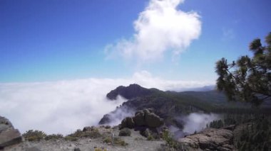 Dağların altındaki bulutların güzel zamanlaması. Kayalıklarda, bulutların üstünde