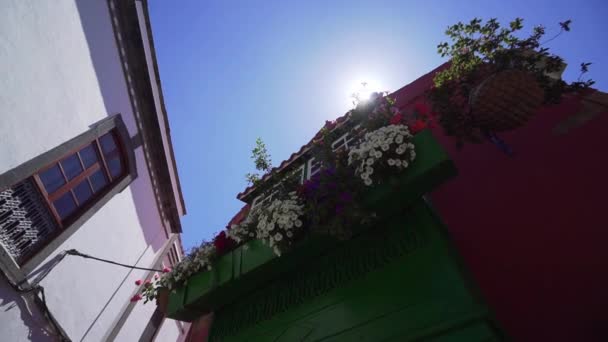 Gran balcón con hermosas flores. Exterior de un edificio rojo medieval español — Vídeos de Stock