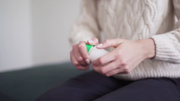 Une femme ouvre un pot de médicament, verse une pilule dans sa paume et prend un antibiotique. Rhume, saison grippale. Une femme malsaine est traitée avec des antidouleurs — Video