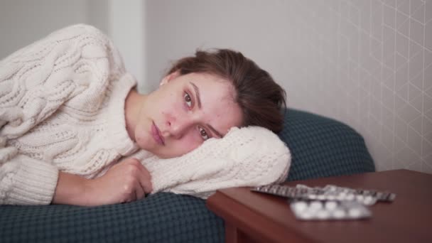 Женский портрет в постели - Айлинг белая женщина на больничном лежит в белом свитере в постели в спальне. Сезон гриппа и холодного вируса в болезни — стоковое видео