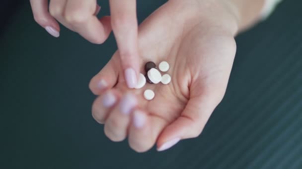 Medicamentos orgánicos y naturales. Pastillas en la mano de una palma joven femenina. Ginseng, calcio, vitaminas y minerales en la mano — Vídeo de stock