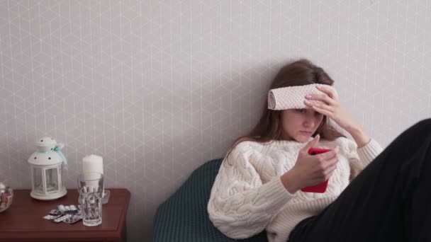 한 젊은 여자는 스마트폰으로 원격 의료를 사용하여 의사에게 병의 증세를 설명한다. 의사와 비디오 통화, 독감 과추운 계절의 환자 상담 — 비디오