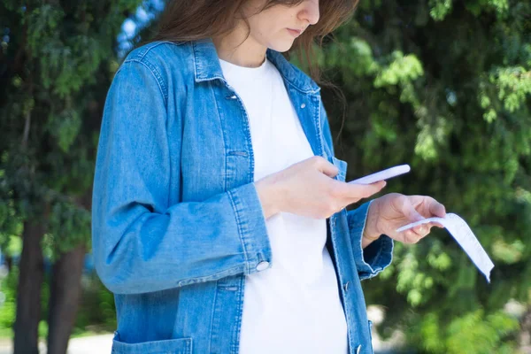 QR taraması. Kız dışarıdan gelen çekteki şifreyi tarıyor.