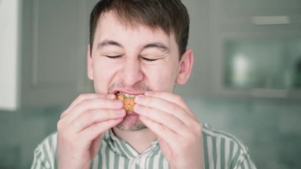 Fűszeres csirkét eszik. Csípős csirkeszárnyak, a fickó leharapja a fűszeres csirkét, kinyitja a szemét és a száját. — Stock videók