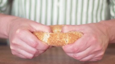 Eller ekmeği bölüşür. Zararlı karbonhidratlar. Baker taze ekmeği yakın plan çeker.