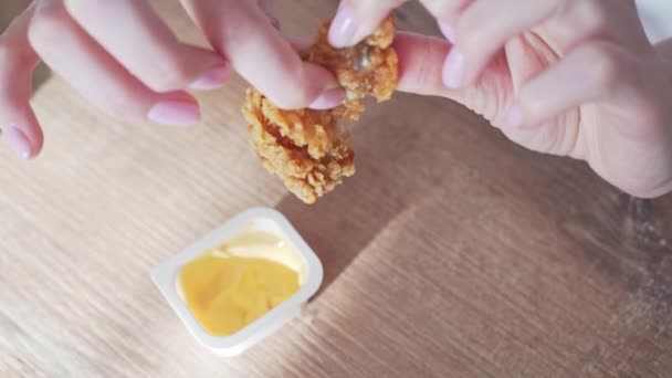 Nuggets werden gebrochen und in Soße getaucht. Chicken Fast Food, gebratener Flügel in Paniermehl in Frauenhand — Stockvideo