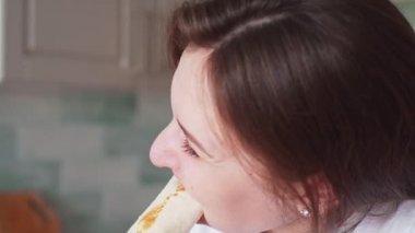 Bir kadın rulo yer, fast food. Shaurma kadınların elinde. Kız kebap yer.