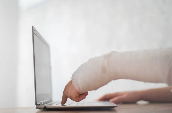 Людина з зламаною рукою натискає кнопку. Спілкування в Інтернеті з обмеженнями на здоров "я — стокове фото